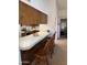 Kitchen bar with seating for three featuring tile countertops and wood cabinetry at 402 W Grandview Rd, Phoenix, AZ 85023