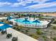 Aerial view of community swimming pool with splash pad, lounge chairs and tables for residents enjoyment at 16013 W Cottontail Ln, Surprise, AZ 85387