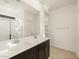 Bathroom featuring double sinks, quartz countertops, dark wood cabinets, and tiled floors at 16039 W Desert Hollow Dr, Surprise, AZ 85379