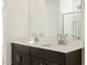 Bathroom with double sink vanity with quartz countertop and dark wood cabinets at 16039 W Desert Hollow Dr, Surprise, AZ 85379