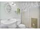 Stylish bathroom featuring a pedestal sink, a toilet, and a separate shower with glass doors at 11275 N 99Th Ave # 145, Peoria, AZ 85345