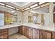 Bathroom with floral wallpaper, double sinks with vanities, and large mirrors over sinks at 11275 N 99Th Ave # 145, Peoria, AZ 85345