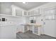 Laundry and utility room featuring bright white walls, gray cabinets, and laminate floors at 11275 N 99Th Ave # 145, Peoria, AZ 85345
