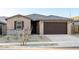 Charming single-story home features a brown two-car garage and a low maintenance gravel front yard at 22455 W Pontiac Dr, Surprise, AZ 85387