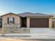 Charming single-story home features a brown two-car garage and a low maintenance gravel front yard at 22455 W Pontiac Dr, Surprise, AZ 85387