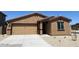 Single-story home featuring an attached two-car garage, a neutral color scheme, and minimal landscaping at 24592 W St Anne Ave, Buckeye, AZ 85326