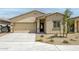Beige one-story home with a two-car garage, desert landscaping and neutral trim at 24592 W St Anne Ave, Buckeye, AZ 85326