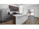 Modern kitchen features stainless steel appliances, gray cabinets, granite countertops, and a center island with a sink at 24593 W St Catherine Ave, Buckeye, AZ 85326