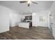 Spacious open-concept living area into kitchen featuring wood-look flooring and a ceiling fan at 24593 W St Catherine Ave, Buckeye, AZ 85326