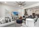 Living room with gray sofas, ottoman, and a large TV at 9447 W Patrick Ln, Peoria, AZ 85383