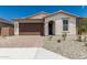 Charming single-story home with a brown garage door and brick paver driveway at 18532 E Dario Rd, Gold Canyon, AZ 85118