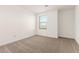 Bright bedroom featuring neutral carpet, a window, and fresh white walls at 8512 N 170Th Ln, Waddell, AZ 85355