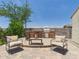 Entertainer's backyard with a built-in BBQ, bar seating, and a comfortable seating area on a brick paver patio at 10637 W Eucalyptus Rd, Peoria, AZ 85383