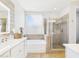 Bright bathroom featuring a soaking tub, glass enclosed shower and dual sink vanity at 10637 W Eucalyptus Rd, Peoria, AZ 85383