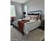 Cozy bedroom featuring a wrought iron bed frame, decorative pillows, and a soft shag rug, creating a comfortable space at 10637 W Eucalyptus Rd, Peoria, AZ 85383