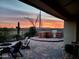 Brick paved patio with fire pit, BBQ, and seating area, overlooking sunset at 10637 W Eucalyptus Rd, Peoria, AZ 85383