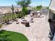 Serene backyard retreat with a fire pit, outdoor kitchen, and comfortable seating under a tree at 10637 W Eucalyptus Rd, Peoria, AZ 85383