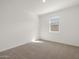 Carpeted bedroom with white walls and natural light from the window at 37014 W La Paz St, Maricopa, AZ 85138