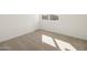 Light-filled bedroom with neutral carpet and a large window for natural light at 37014 W La Paz St, Maricopa, AZ 85138
