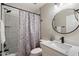 Updated bathroom featuring a shower with tile surround, paisley shower curtain, modern vanity, and round mirror at 1413 E Windsor Ave, Phoenix, AZ 85006