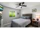 Cozy bedroom featuring a wooden headboard, ceiling fan, and a bright window with a view of lush greenery at 1413 E Windsor Ave, Phoenix, AZ 85006