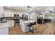 Charming kitchen boasts white cabinets, stainless steel appliances, a center island with bar stool seating, and wood floors at 1413 E Windsor Ave, Phoenix, AZ 85006