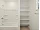Clean bathroom with a bathtub, shower, and built-in shelving at 37405 W San Clemente St, Maricopa, AZ 85138