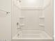 Bright bathroom with a shower/tub combo and built-in shelving at 37405 W San Clemente St, Maricopa, AZ 85138
