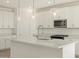 Modern kitchen with white cabinets, quartz countertops and island at 37405 W San Clemente St, Maricopa, AZ 85138
