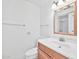 Bright bathroom with a vanity and large mirror, featuring a clean white toilet and sink at 10026 W Lancaster Dr, Sun City, AZ 85351