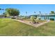 Community outdoor patio with dining, lush green lawn, mature trees, and well-maintained landscaping at 10026 W Lancaster Dr, Sun City, AZ 85351