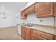 Well-lit kitchen with ample wood cabinetry, dual sink, and a view into the living area at 10026 W Lancaster Dr, Sun City, AZ 85351