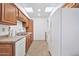Bright kitchen featuring white appliances, wooden cabinets, and dual skylights for natural lighting at 10026 W Lancaster Dr, Sun City, AZ 85351