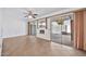 Open living area with tile floors, ceiling fan, and access to the patio through sliding glass doors at 10026 W Lancaster Dr, Sun City, AZ 85351