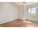 This bedroom features wood-style floors, a ceiling fan, and a window with a view at 1926 E Siesta Ln, Phoenix, AZ 85024