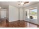 This bedroom has wood-style floors, a ceiling fan, and a sliding glass door leading to a patio at 1926 E Siesta Ln, Phoenix, AZ 85024