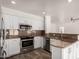 Updated kitchen with granite countertops, stainless appliances, and white cabinets at 1926 E Siesta Ln, Phoenix, AZ 85024