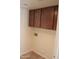 Functional laundry room with overhead cabinets and washer-dryer hookups, offering convenience and storage at 1926 E Siesta Ln, Phoenix, AZ 85024