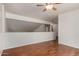 This loft area has wood-style floors, a ceiling fan, and a view of the staircase at 1926 E Siesta Ln, Phoenix, AZ 85024