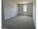 Bedroom features carpeted floors, window, and neutral walls, providing a comfortable and inviting space at 46963 W Coe St, Maricopa, AZ 85139