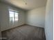 A bright and spacious bedroom with carpeted floors, a large window, and neutral paint at 46963 W Coe St, Maricopa, AZ 85139