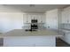 Kitchen island features a sink and quartz countertops, with stainless steel appliances at 46963 W Coe St, Maricopa, AZ 85139