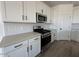 Updated kitchen with stainless steel appliances, quartz countertops, and white cabinets at 46963 W Coe St, Maricopa, AZ 85139