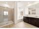 Bright bathroom featuring a shower with glass doors, bathtub, and dual sinks at 4994 W Hunter Trl, San Tan Valley, AZ 85144