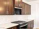 Kitchen with stainless steel microwave, gas range, quartz countertops, and dark wood cabinets at 4994 W Hunter Trl, San Tan Valley, AZ 85144