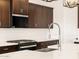 Close-up of kitchen with a stainless steel faucet, gas range and stainless steel microwave at 4994 W Hunter Trl, San Tan Valley, AZ 85144