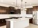 Modern kitchen features stainless steel appliances and an eat-in island with pendant lighting at 4994 W Hunter Trl, San Tan Valley, AZ 85144