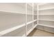 Walk-in pantry with multiple white shelves for storage and tile flooring at 4994 W Hunter Trl, San Tan Valley, AZ 85144