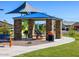 Charming picnic area under a shade structure with stone pillars, complete with a grill and picnic table at 4994 W Hunter Trl, San Tan Valley, AZ 85144