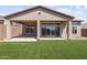 Backyard featuring artificial grass and covered patio attached to a modern home at 32513 N 135Th Dr, Peoria, AZ 85383